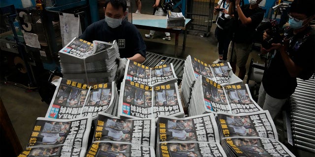 A worker packs copies of Apple Daily newspaper at the printing house in Hong Kong, early Friday, June 18, 2021.