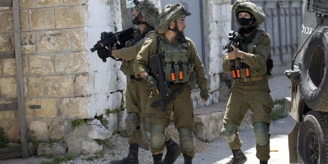 Israeli soldiers patrol after a soldier was killed when a rock thrown off a rooftop struck him in the head during an arrest raid, in the village of Yabad near the West Bank city of Jenin, in May 2020. The Israeli military says it is reining in a controversial practice of conducting late-night raids of Palestinian homes in the West Bank aimed at gathering information about the houses and their inhabitants.