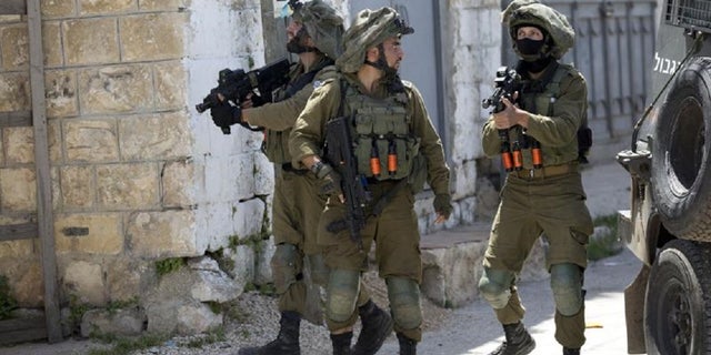 Israeli soldiers patrol after a soldier was killed when a rock thrown off a rooftop struck him in the head during an arrest raid, in the village of Yabad near the West Bank city of Jenin, in May 2020. The Israeli military says it is reining in a controversial practice of conducting late-night raids of Palestinian homes in the West Bank aimed at gathering information about the houses and their inhabitants. 