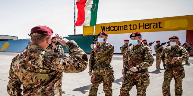 Italian army soldiers carry the flag of the Folgore Brigade as the last Italian troops withdraw from Afghanistan in Herat on Tuesday. (AP / Italian Ministry of Defense)