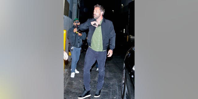 Ben Affleck attempted to hide his face from cameras with his cell phone while stepping out for dinner in Beverly Hills with JLo.