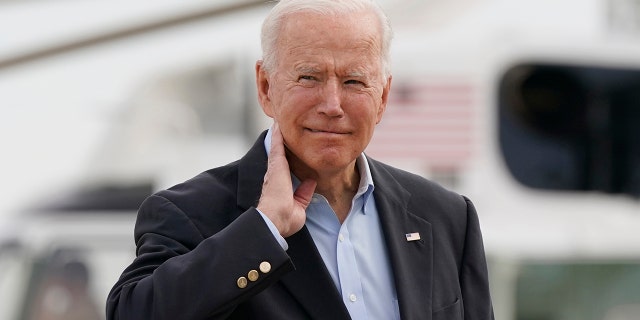 President Joe Biden pantomimes how he earlier had to brush a cicada off his neck as he and first lady Jill Biden prepare to board Air Force One, Wednesday, June 9, 2021, at Andrews Air Force Base, Md. (AP Photo/Patrick Semansky)