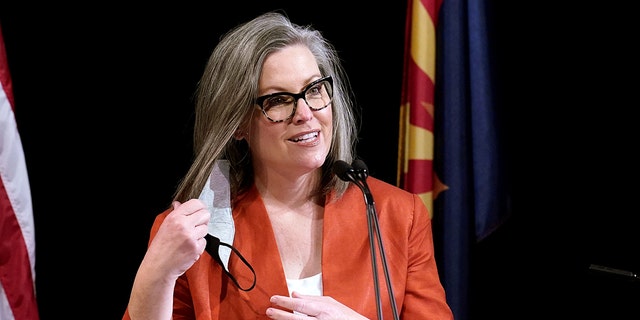Arizona Secretary of State Katie Hobbs removes her face covering as she addresses members of Arizona's Electoral College before her casting of votes in Phoenix, Ariz., Dec. 14, 2020. 