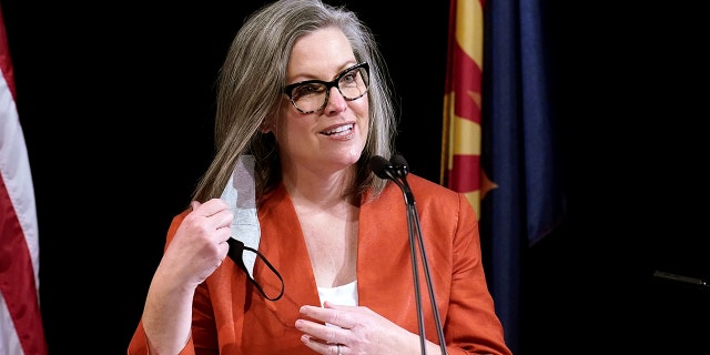 Arizona Secretary of State Katie Hobbs removes her face covering as she addresses members of Arizona's Electoral College before its casting of votes in Phoenix, Ariz., Dec. 14, 2020. 