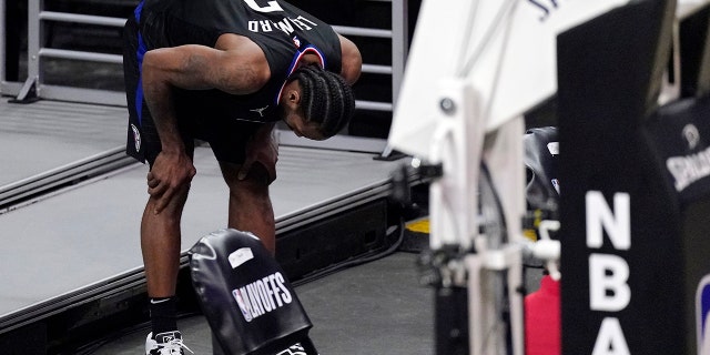 Los Angeles Clippers forward Kawhi Leonard holds his knee after stepping awkwardly during the second half in Game 4 of a second-round NBA basketball playoff series against the Utah Jazz Monday, June 14, 2021, in Los Angeles. (AP Photo/Mark J. Terrill)