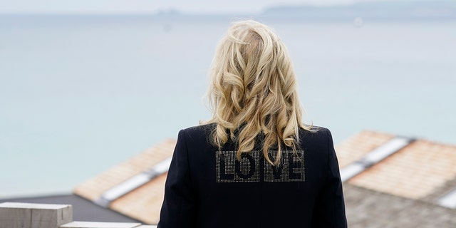 First lady Jill Biden turns around to show the word "love" on the back of her jacket as she speaks with reporters after visiting with Carrie Johnson, wife of British Prime Minister Boris Johnson, ahead of the G-7 summit, Thursday, June 10, 2021, in Carbis Bay, England. (AP Photo/Patrick Semansky)