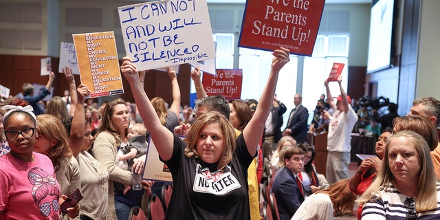 Shelley Slebrch and other angry parents and community members protest after a Loudoun County School Board meeting was halted by the school board because the crowd refused to quiet down.