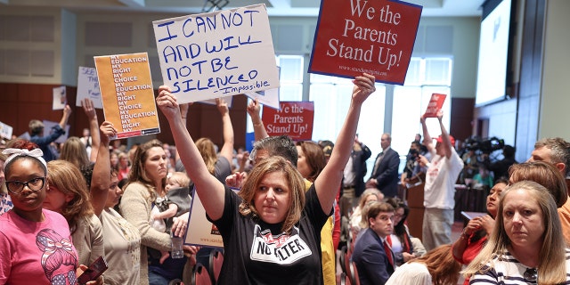 Shelley Slebrch and other angry parents and community members protest after a Loudoun County School Board meeting was halted by the school board because the crowd refused to quiet down, in Ashburn, Virginia, June 22, 2021.