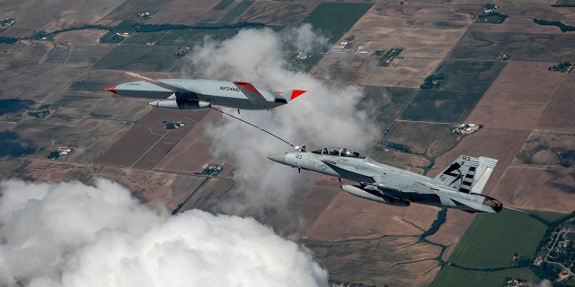 The Boeing MQ-25 T1 test asset transfers fuel to a U.S. Navy F/A-18 Super Hornet on June 4, marking the first time in history that an unmanned aircraft has refueled another aircraft. The MQ-25 Stingray will assume the carrier-based tanking role currently performed by F/A-18s, allowing for better use of the combat strike fighters and helping extend the range of the carrier air wing. (Photo by Kevin Flynn)