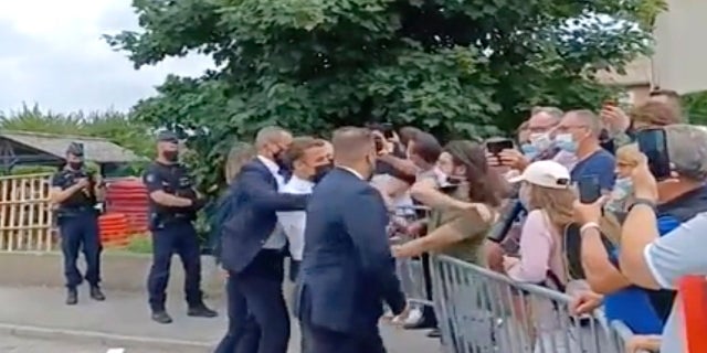 In this image taken from video, French President Emmanuel Macron, center, is slapped by Damien Tarel -- who is in a green T-shirt -- during a visit to Tain-l’Hermitage in France on Tuesday. (BFM TV via AP)