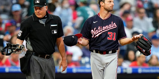 Washington Nationals pitcher Max Scherzer, destra, waits to be checked for foreign substances near home plate umpire Tim Timmons after the first inning of a baseball game against the Philadelphia Phillies, martedì, giugno 22, 2021, a Philadelphia. (AP Photo/Matt Slocum)