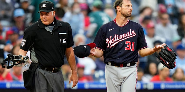 Washington Nationals pitcher Max Scherzer, right, waits to be checked for foreign substances near home plate umpire Tim Timmons after the first inning of a baseball game against the Philadelphia Phillies, Tuesday, June 22, 2021, in Philadelphia. (AP Photo/Matt Slocum)