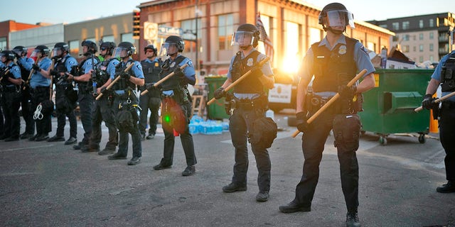 Police descend on the block-long stretch of Lake Street in Uptown just before sunset to dismantle the barricades erected by protesters on June 15, 2021, in Minneapolis. (Jeff Wheeler/Star Tribune via AP)