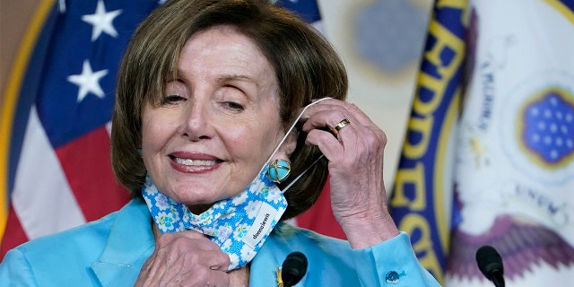 In this May 19, 2021, file photo House Speaker Nancy Pelosi takes off her face mask to talk to reporters on Capitol Hill in Washington, D.C.