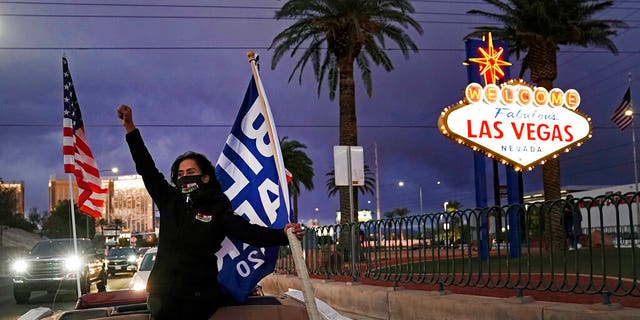 In this November 7, 2020 file photo, Socorro Ulloa, a supporter of then-President-elect Joe Biden and Vice President-elect Kamala Harris, carries flags as he rides in the back of the building. 'a limousine in Las Vegas. Nevada lawmakers have passed a bill to make the state the first to influence the 2024 presidential primary elections.