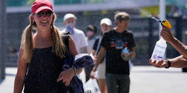 Fans are sprayed with water after events are postponed due to extreme heat at the US Olympic Track and Field Trials on Sunday, June 27, 2021 in Eugene, Ore. (AP Photo/ Ashley Landis)