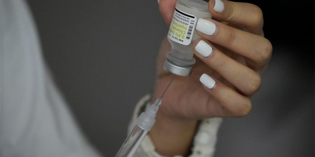 A health worker prepares a dose of the Pfizer COVID-19 vaccine, at the city hall in Quezon city, Philippines on Monday, June 21, 2021. The Philippine government has signed a purchase deal for 40 million doses of Pfizer COVID-19 vaccine in the largest such agreement it has managed to negotiate this year after huge demands from wealthy countries started to ease. (AP Photo/Aaron Favila)