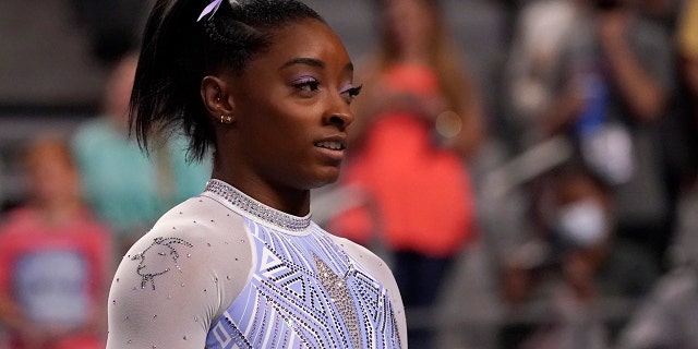 Simone Biles waits her turn to compete on the balance beam during the U.S. Gymnastics Championships, Friday, June 4, 2021, in Fort Worth, Texas. Biles wore a goat laced into her leotard during the competition. (AP Photo/Tony Gutierrez)