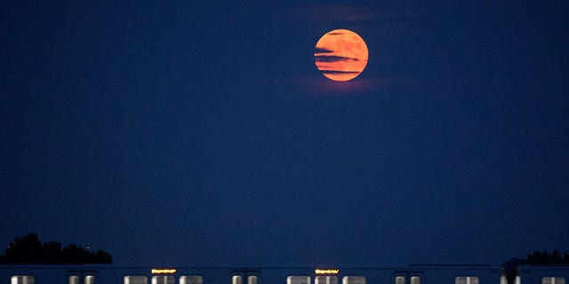 A lua nasce quando um carro do Metrorail cruza o rio Potomac em Washington, DC, em 16 de julho de 2019. 