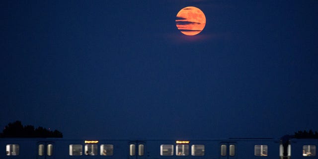 A lua nasce quando um carro do Metrorail cruza o rio Potomac em Washington, DC, em 16 de julho de 2019. 