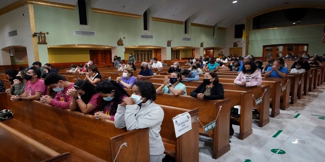 People pray late Saturday during a prayer vigil for the victims and families of the Champlain Towers collapsed building, at the nearby St. Joseph Catholic Church in Miami Beach, Fla.  (AP)