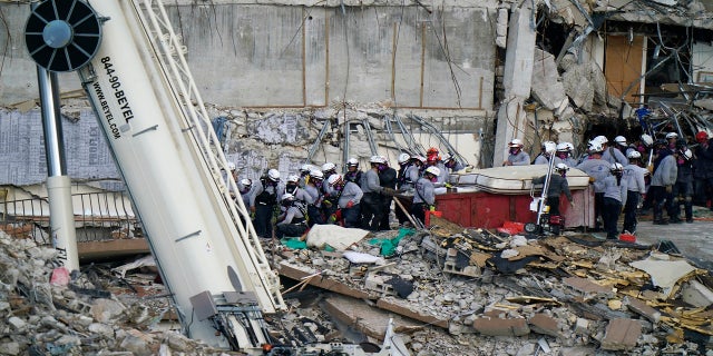 Workers search the rubble at the Champlain Towers South Condo on Monday. (AP)