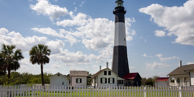Tybee Island Lighthouse, a historic lighthouse with colonial era ties near Savannah, Georgia. Classic lighthouse image with fluffy clouds and sunny skies.