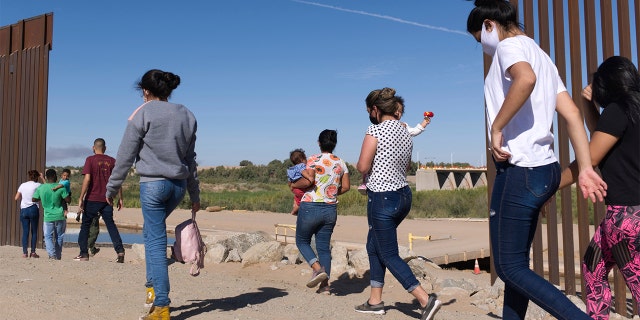 In this Tuesday, June 8, 2021, photo, a group of Brazilian migrants make their way around a gap in the U.S.-Mexico border in Yuma, Ariz., seeking asylum in the United States after crossing over from Mexico. (AP Photo/Eugene Garcia)
