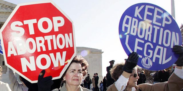 FILE - In this Nov. 30, 2005 file photo, an anti-abortion supporter stands next to a pro-choice demonstrator outside the U.S. Supreme Court in Washington. The new poll from The Associated Press-NORC Center for Public Affairs Research finds 61{dcfa4b42334872b3517041d7075c48816e8f617446b245cec30e8949517ffd84} of Americans say abortion should be legal in most or all circumstances in the first trimester of a pregnancy. However, 65{dcfa4b42334872b3517041d7075c48816e8f617446b245cec30e8949517ffd84} said abortion should usually be illegal in the second trimester, and 80{dcfa4b42334872b3517041d7075c48816e8f617446b245cec30e8949517ffd84} said that about the third trimester. (AP Photo/Manuel Balce Ceneta)