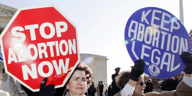 FILE - In this Nov. 30, 2005 file photo, an anti-abortion supporter stands next to a pro-choice demonstrator outside the U.S. Supreme Court in Washington. The new poll from The Associated Press-NORC Center for Public Affairs Research finds 61{dcfa4b42334872b3517041d7075c48816e8f617446b245cec30e8949517ffd84} of Americans say abortion should be legal in most or all circumstances in the first trimester of a pregnancy. However, 65{dcfa4b42334872b3517041d7075c48816e8f617446b245cec30e8949517ffd84} said abortion should usually be illegal in the second trimester, and 80{dcfa4b42334872b3517041d7075c48816e8f617446b245cec30e8949517ffd84} said that about the third trimester. (AP Photo/Manuel Balce Ceneta)