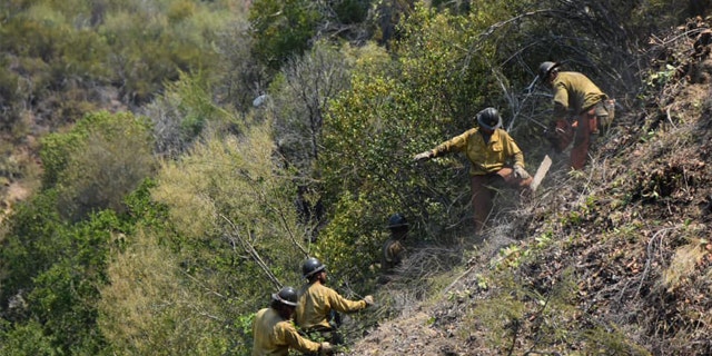 A group of firefighting monks was ready to defend a Buddhist monastery being threatened Tuesday by a wildfire burning in the rugged central coast mountains south of Big Sur.