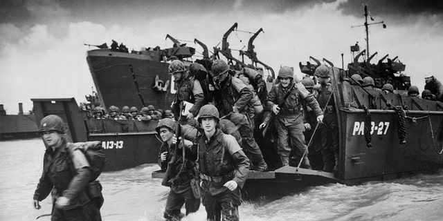 Reinforcements disembark from a landing barge in Normandy during the Allied Invasion of France on D-Day.