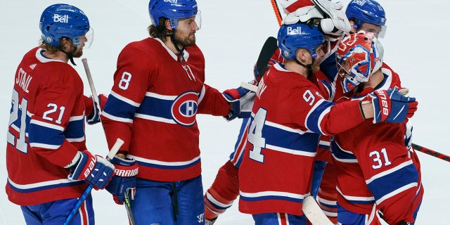 Montreal's Eric Staal, Ben Chiarot and Corey Perry, left to right, celebrate the victory with goalkeeper Carey Price after overtime of Game 6 of the NHL Hockey Stanley Cup semi-final series on Thursday. On June 24, 2021 in Montreal (Paul Chiasson/The Canadian Press via AP)