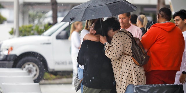 People embrace at the Surfside Community Center where authorities are taking residents and relatives from a partially collapsed building in Miami Beach, Florida, on June 24, 2021. (REUTERS/Marco Bello)