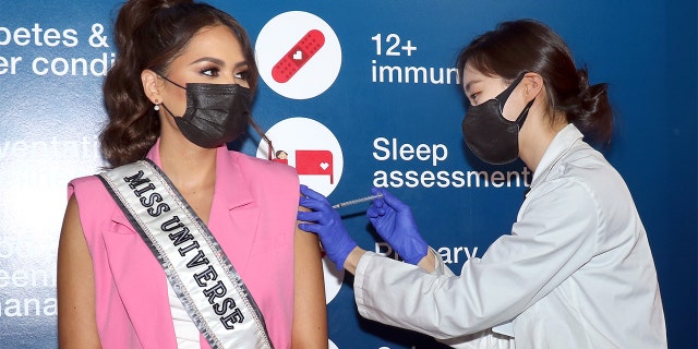 Miss Universe Andrea Meza (L) receives her COVID-19 vaccine as her first official act as Miss Universe at CVS on May 26, 2021, in New York City.