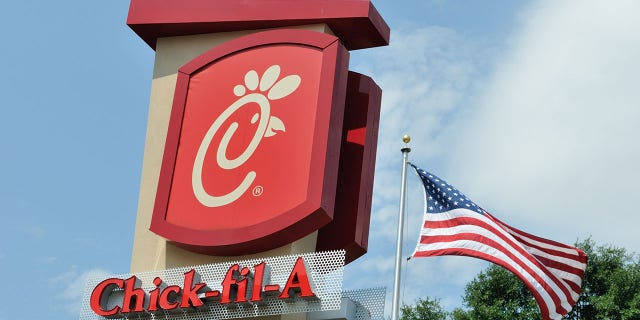 A picture of a Chick-fil-a sign with an American flag in the background.