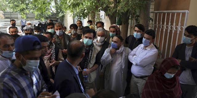 Residents, wearing face masks to help curb the spread of the coronavirus, line up to receive the Sinopharm COVID-19 vaccine at a vaccination center, in Kabul, Afghanistan, Wednesday, June 16, 2021.