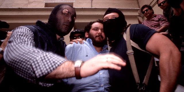 Giovanni Brusca, center, is seen during his capture in 1996. (Getty Images)