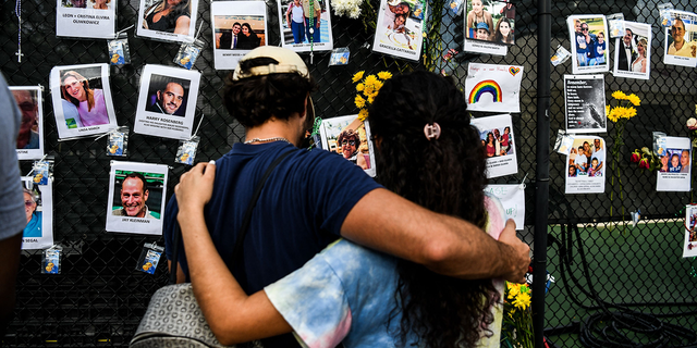 People visit a makeshift memorial for victims of the building collapse near the site of the accident in Surfside, Fla., June 27, 2021