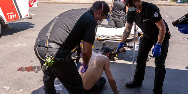 Salem Fire Department Capt. Matt Brozovich and Falck Northwest ambulance personnel help treat a man experiencing heat exposure at a cooling center during a heatwave in Salem, Oregon, on June 26, 2021. 