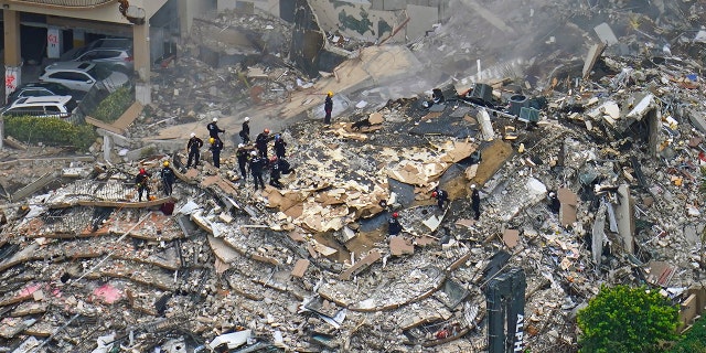 Rescue workers search in the rubble at the Champlain Towers South Condo, 星期五, 六月 25, 2021, in Surfside, 弗拉. The seaside condominium tower collapsed on Thursday.