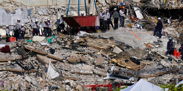 Workers search the rubble at the Champlain Towers South Condo on Monday. (AP)