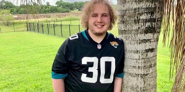 In this April 18, 2021 photo provided by Jennifer Sampson, her son Zach Sampson, 16, poses in his Florida yard. Sampson was hospitalized twice during the pandemic after feeling suicidal.