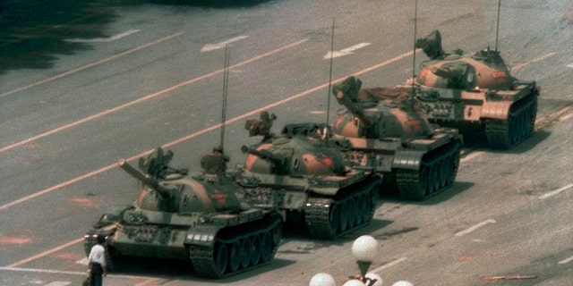 In this June 5, 1989, lêerfoto, a man stands alone in front of a line of tanks heading east on Beijing's Changan Boulevard in Tiananmen Square, Sjina. (AP Photo/Jeff Widener, lêer)