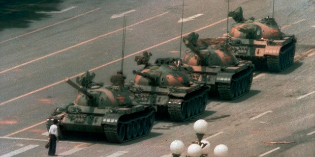 In this June 5, 1989, file photo, a man stands alone in front of a line of tanks heading east on Beijing's Changan Boulevard in Tiananmen Square, China. (AP Photo/Jeff Widener, File)