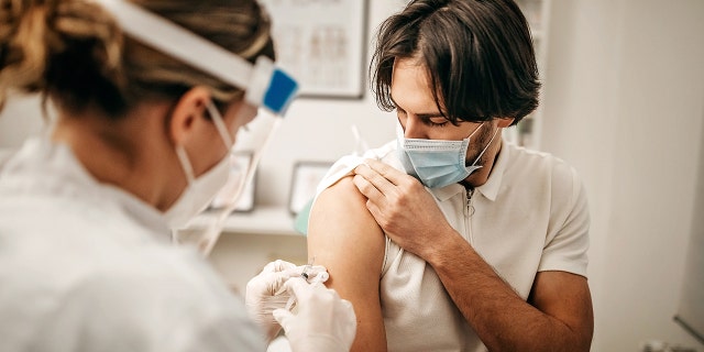 Medical doctor giving injection to make antibody for coronavirus.