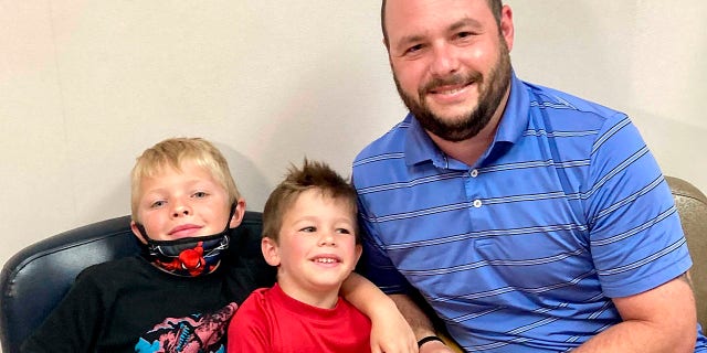 June 7, 2021: From left, 7-year-old Russell Bright, 5-year-old Tucker Bright, and dad Adam Bright pose for a picture at Ochsner Medical Center in Jefferson, La.