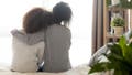 Loving african american single mother sister embrace teen daughter sit on bed looking at window, parent mom hug support protect teenage girl, family trust hope talk understanding concept, rear view (iStock)
