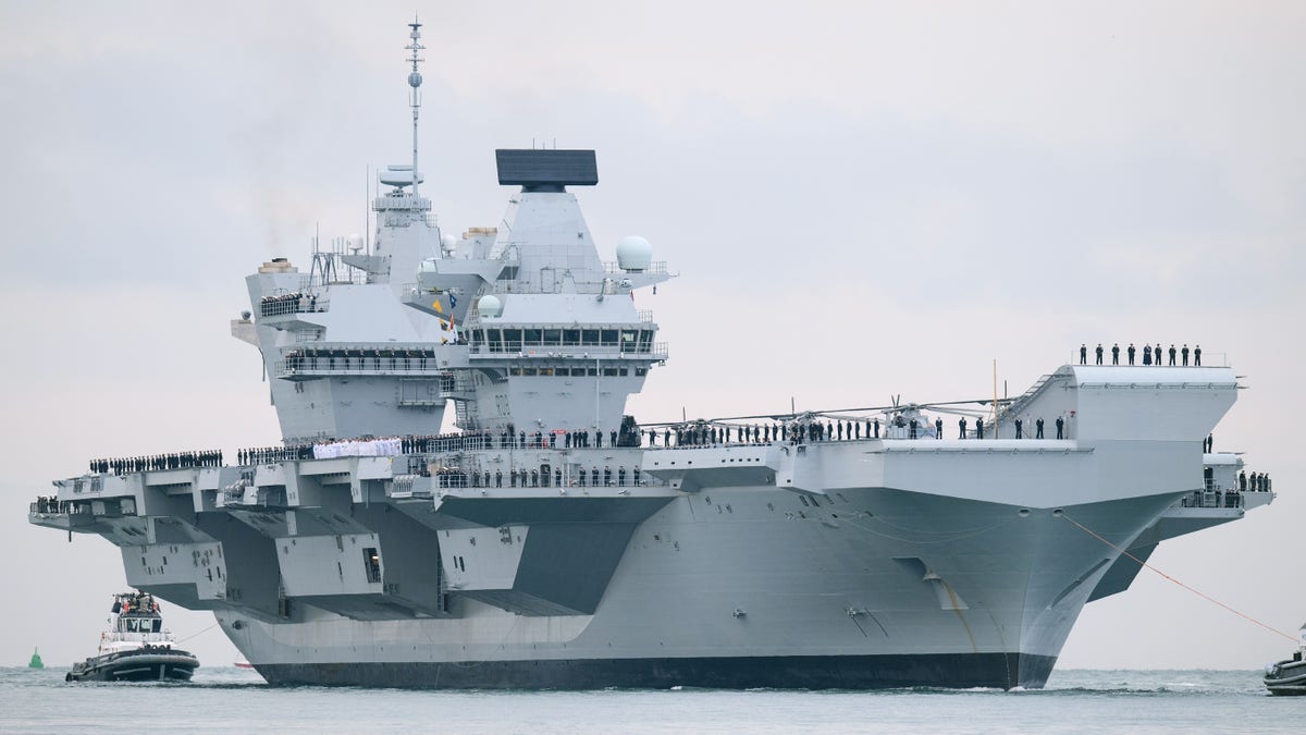 PORTSMOUTH, ENGLAND - AUGUST 16: The HMS Queen Elizabeth supercarrier heads into port on August 16, 2017 in Portsmouth, England. The HMS Queen Elizabeth is the lead ship in the new Queen Elizabeth class of supercarriers. Weighing in at 65,000 tonnes she is the largest war ship deployed by the British Royal Navy. She (Photo by Leon Neal/Getty Images)