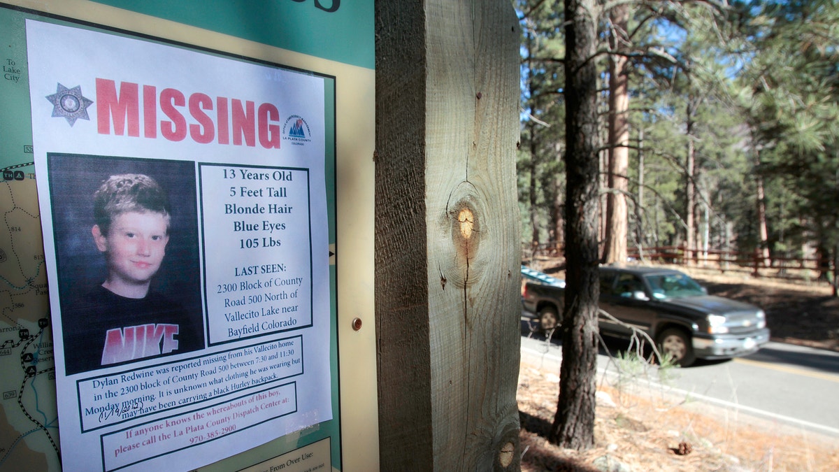 In this Nov. 26, 2012, file photo, a missing poster of 13-year-old Dylan Redwine hangs on a trail head sign next to Vallecito Reservoir in Vallecito, Colo. 
